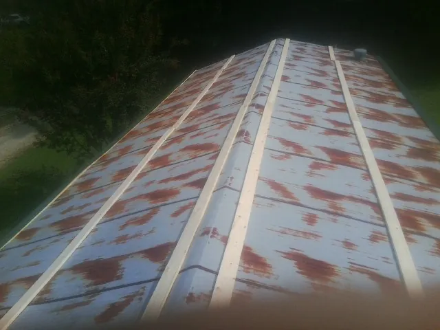 Rusted metal roof panels with new wood purlins before replacement — Storm Damage Roof Repair in Calypso by Roofing Brothers