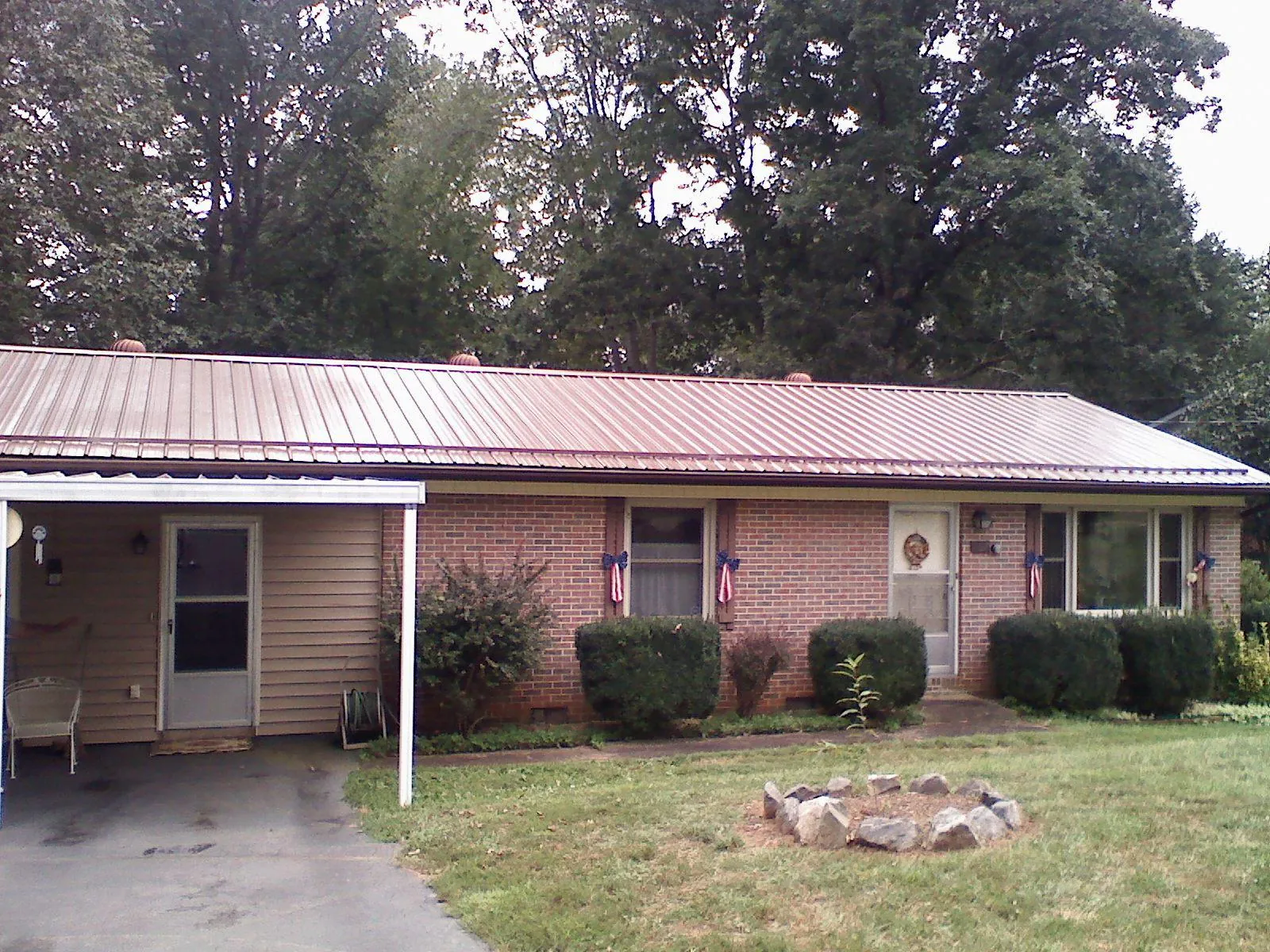 Bronze metal roof and carport on a brick ranch home — Roof Repair work by our crew in Calypso