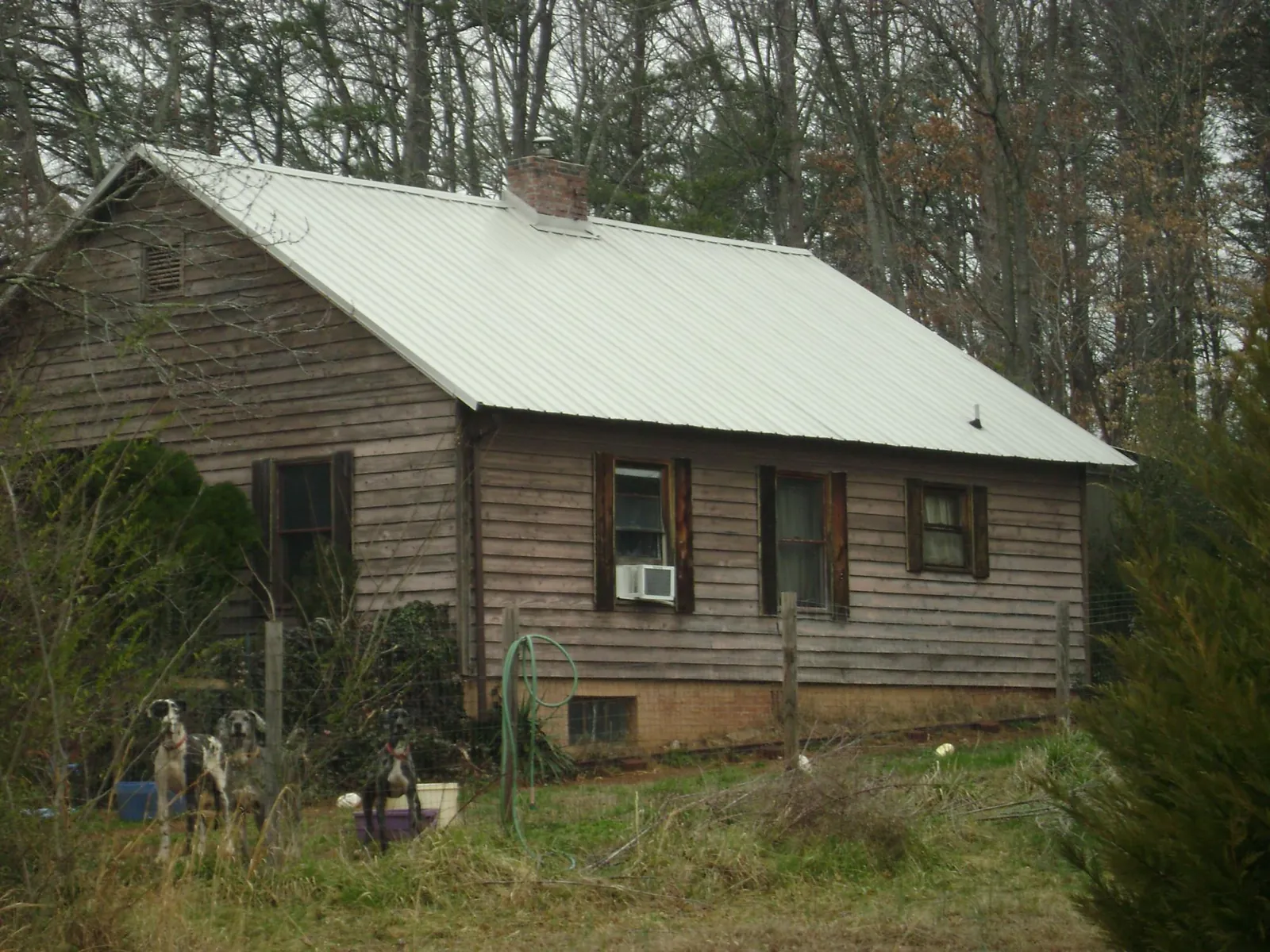 White metal roof on an old wood sided farmhouse, from a Metal Roof Installation job in Calypso